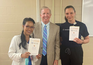 jeff whitehorn, author of leadership treasure, with two people holding his book